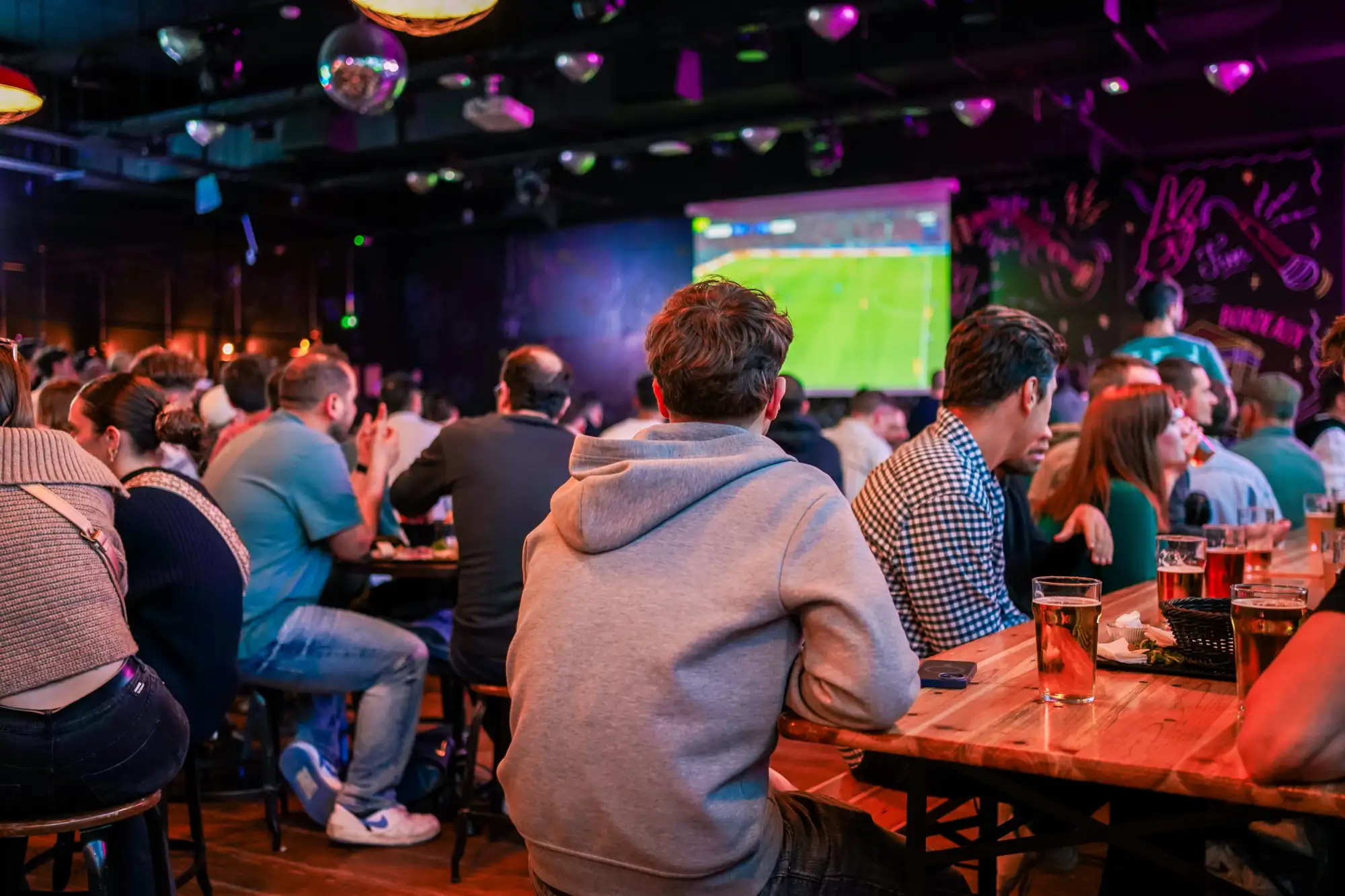 Clients regardants le football sur l'écran géant au Délirium Café Bordeaux