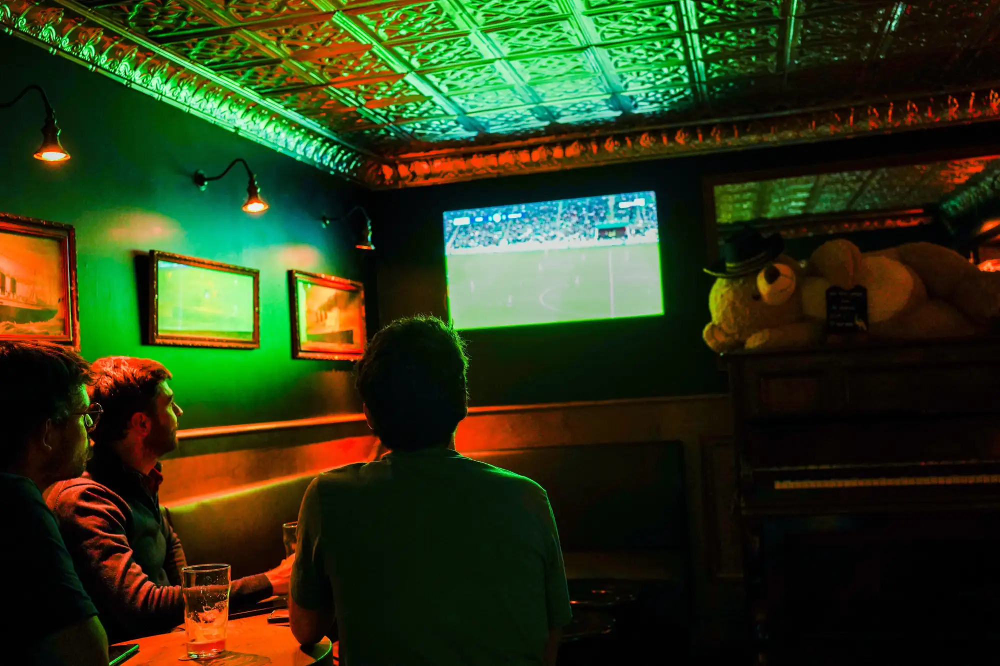 Clients regardant le sport au bar Le Singe Vert